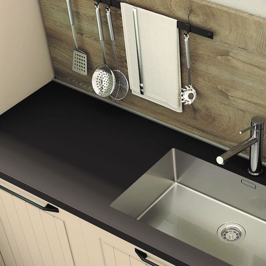 Top cucine in hpl nero abbinato a lavello e miscelatore in acciaio inox e cucina bianca con maniglie nere, lo schienale alto in legno ripara il muro da schizzi